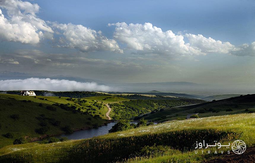 دشتی سرسبز که رودی از میان آن می‌گذرد و چند کلبه‌ی روستایی